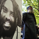 A protestor stands next to an image of Mumia Abu-Jamal outside the US Department of Justice on April 24, 2012 in Washington, DC, calling for the release from prison of the ex-Black Panther militant, who was convicted for the killing of a white police officer in 1981 and sentenced to death. In December 2011 prosecutors gave up their effort to execute Abu-Jamal, who supporters believe is innocent and was framed for the murder in the racially charged case. Supporters decided to hold their demonstration on April 24, 2012, Abu-Jamal's 58th birthday. AFP PHOTO / Mandel NGAN (Photo credit should read MANDEL NGAN/AFP/Getty Images)
